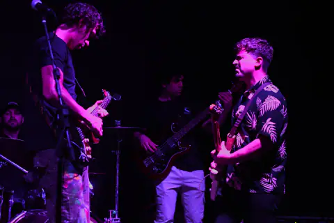 Banda tocando en vivo bajo luz violeta