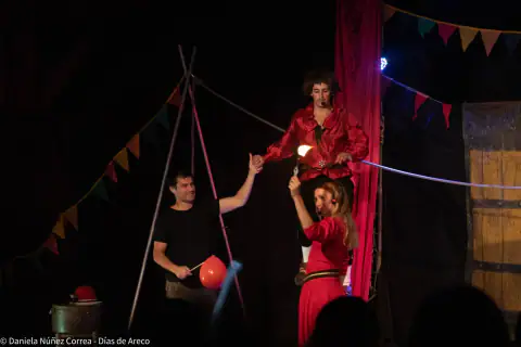 Artistas de circo en escena con vestuario rojo