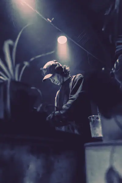 Artista bajo un foco en ambiente oscuro y brumoso