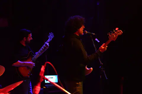 Músicos de perfil en contraluz rojo y violeta