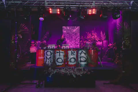 Escenario Otra Mood con luces magenta y tambores pintados